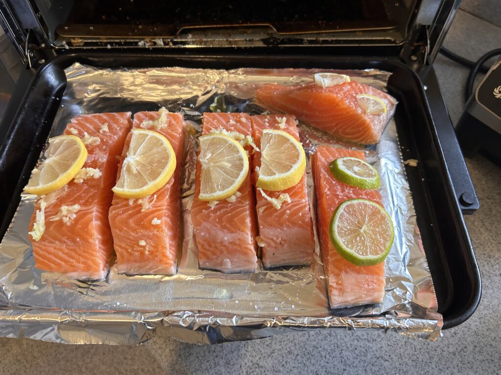 Salmon fillets topped with crushed garlic, lemon juice, olive oil and lemon slices